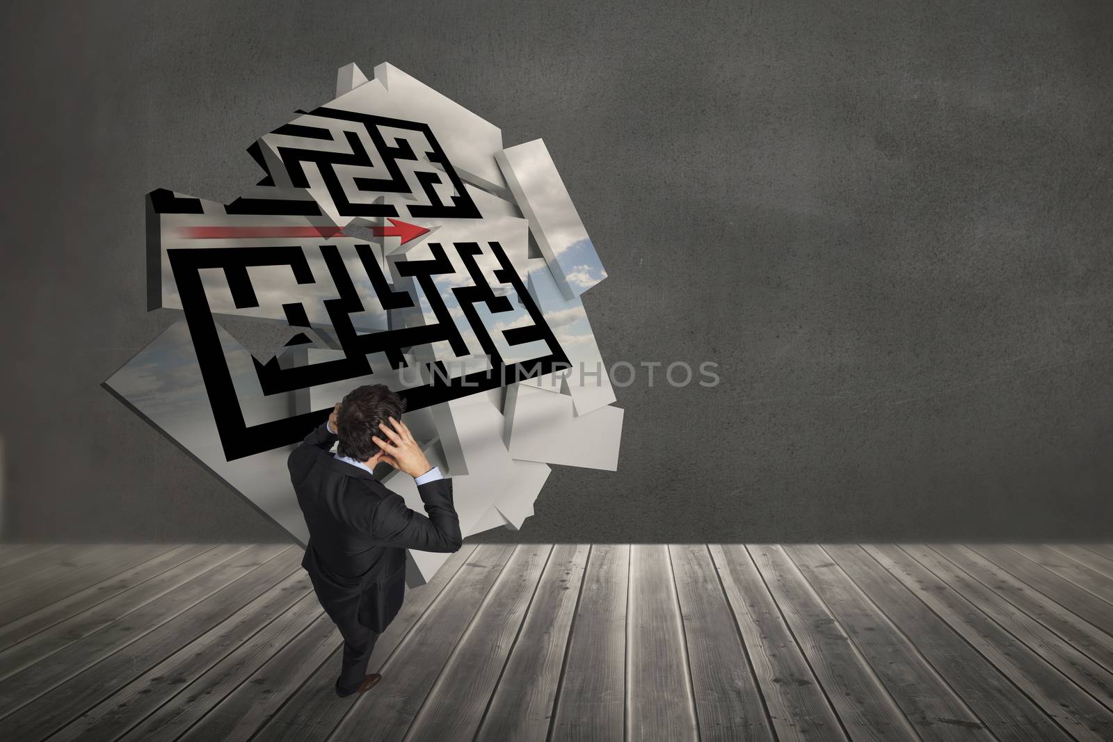 Stressed businessman with hands on head against maze graphic on abstract screen in room