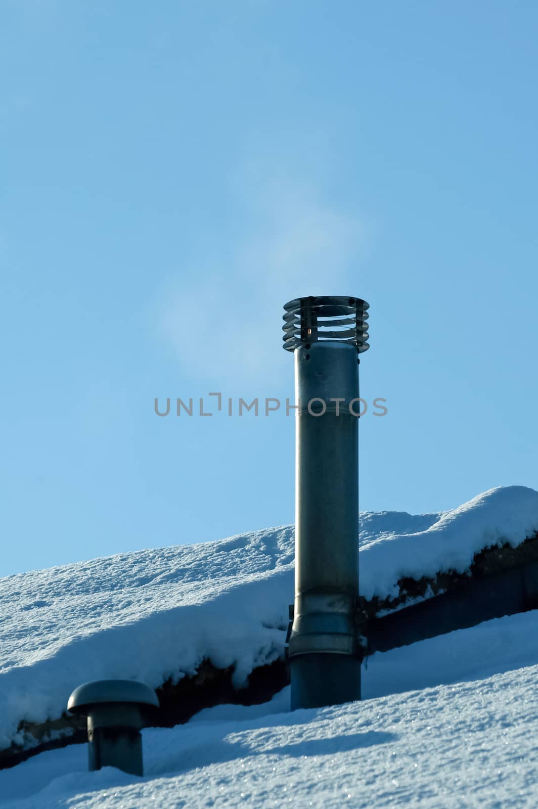 smoking chimney on a snow covered rooftop