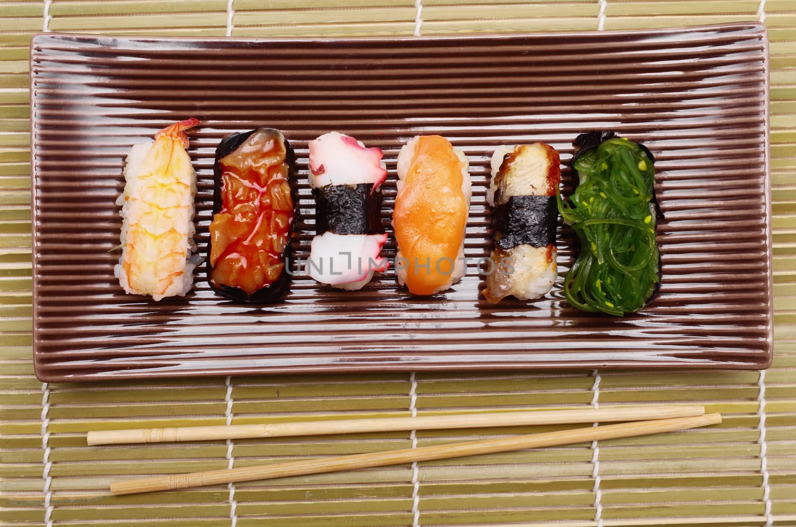 Sushi nigiri in with dish with bamboo sticks 