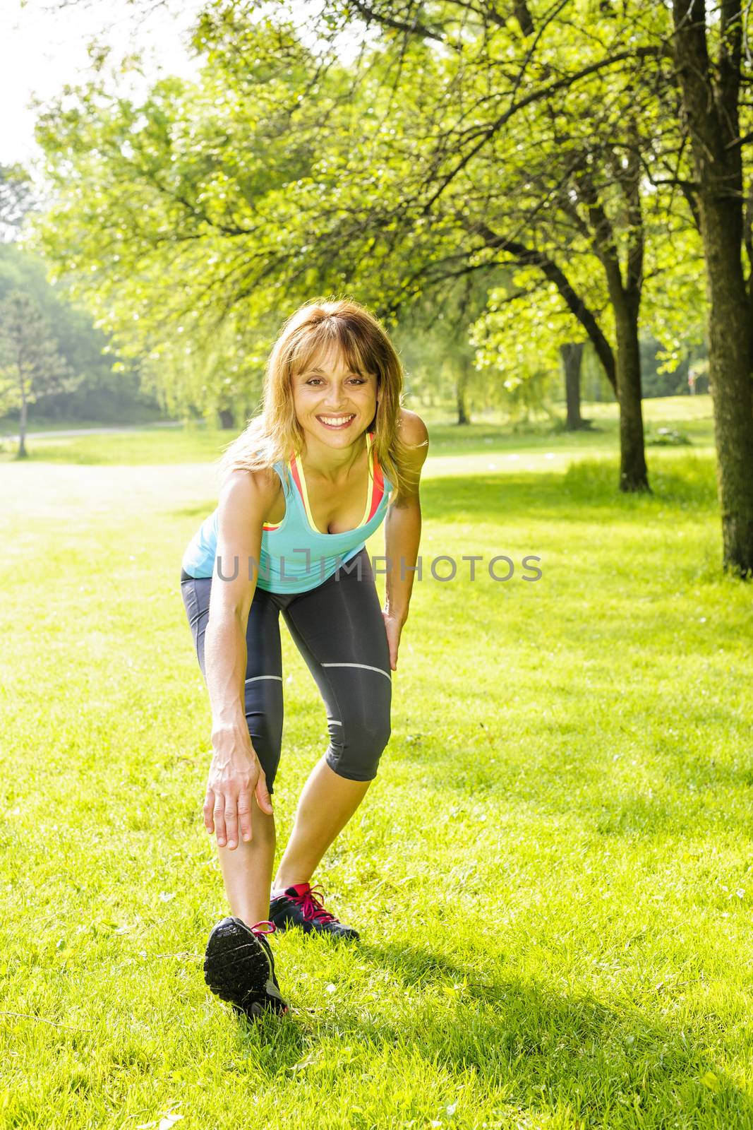 Woman stretching in park by elenathewise