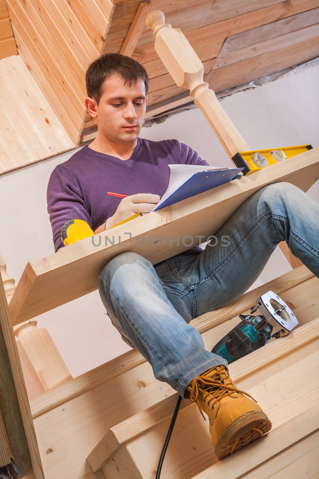 worker writing in clipboard with wooden board on her legs