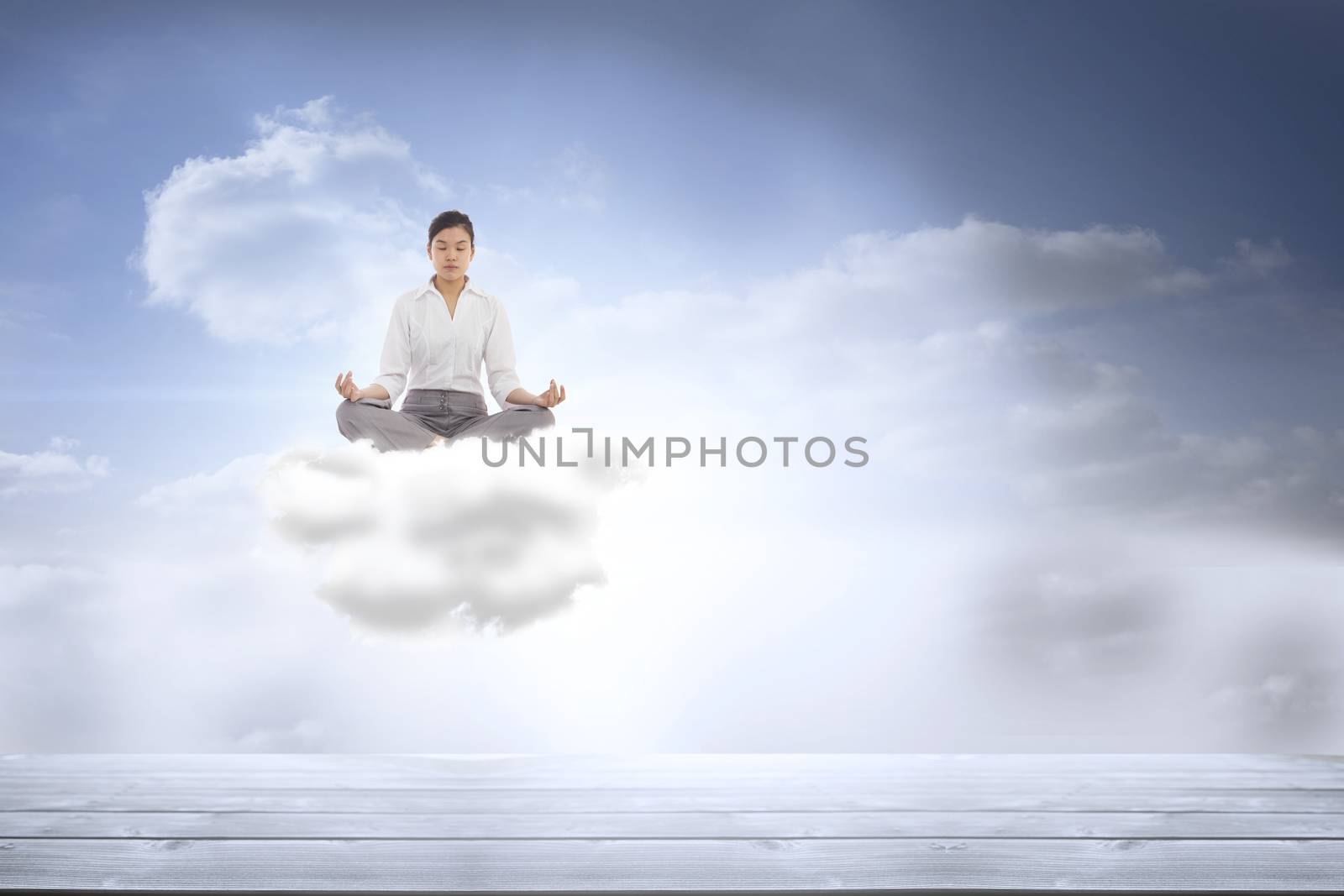 Businesswoman sitting in lotus pose against beautiful blue sky with clouds