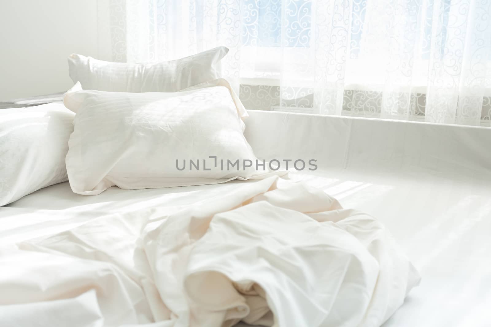 Photo of untidy bed against window