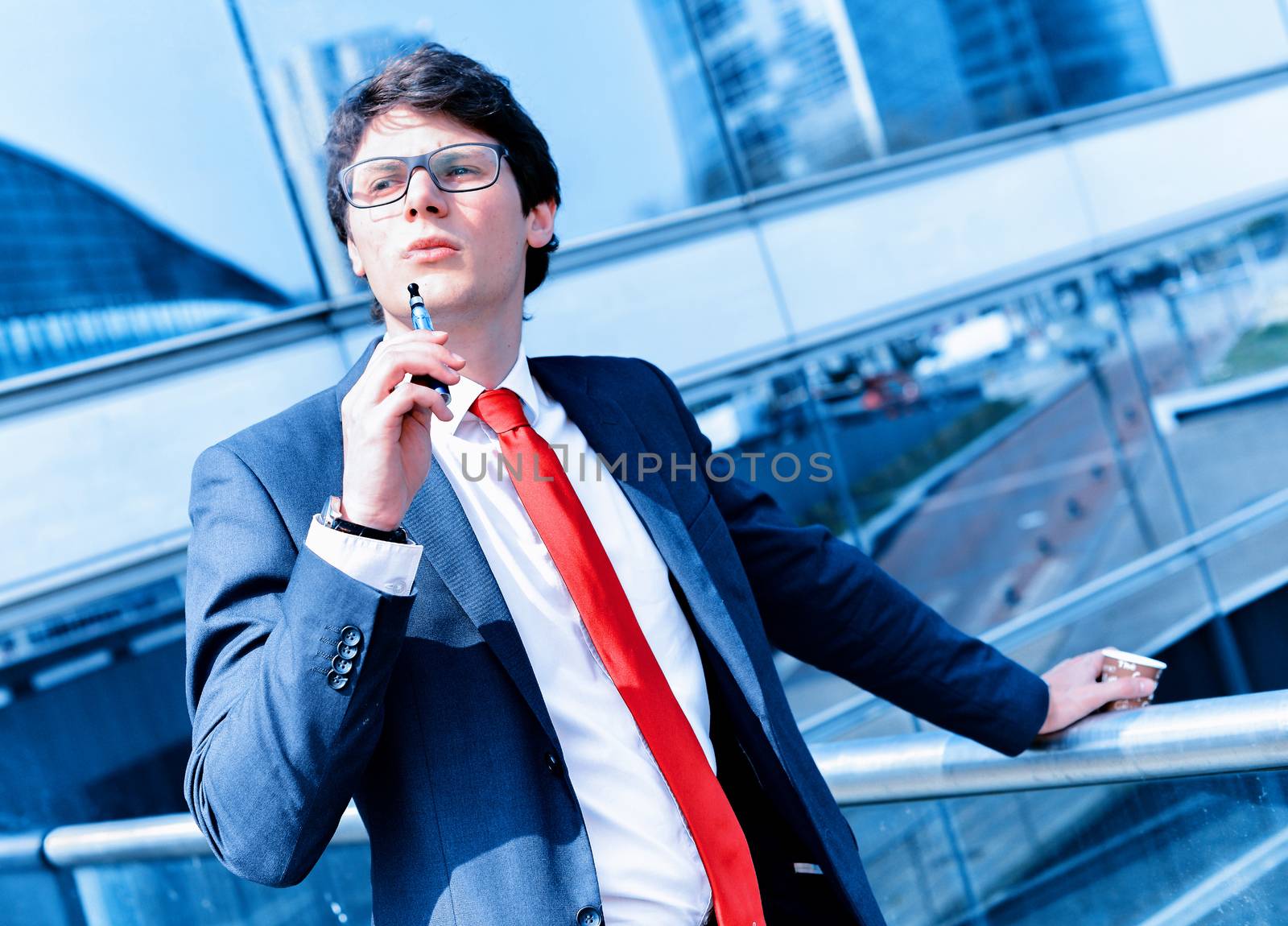 Cute young adult man inhaling from an electronic cigarette