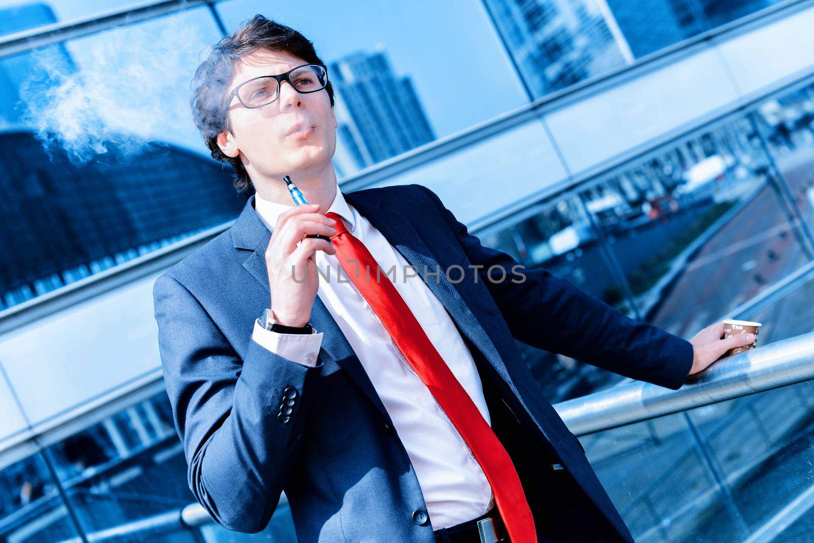 Cute young adult man inhaling from an electronic cigarette