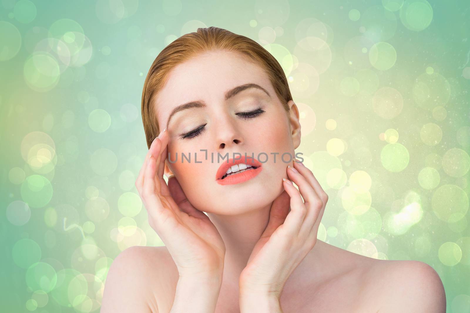 Beautiful redhead posing with hands against green abstract light spot design