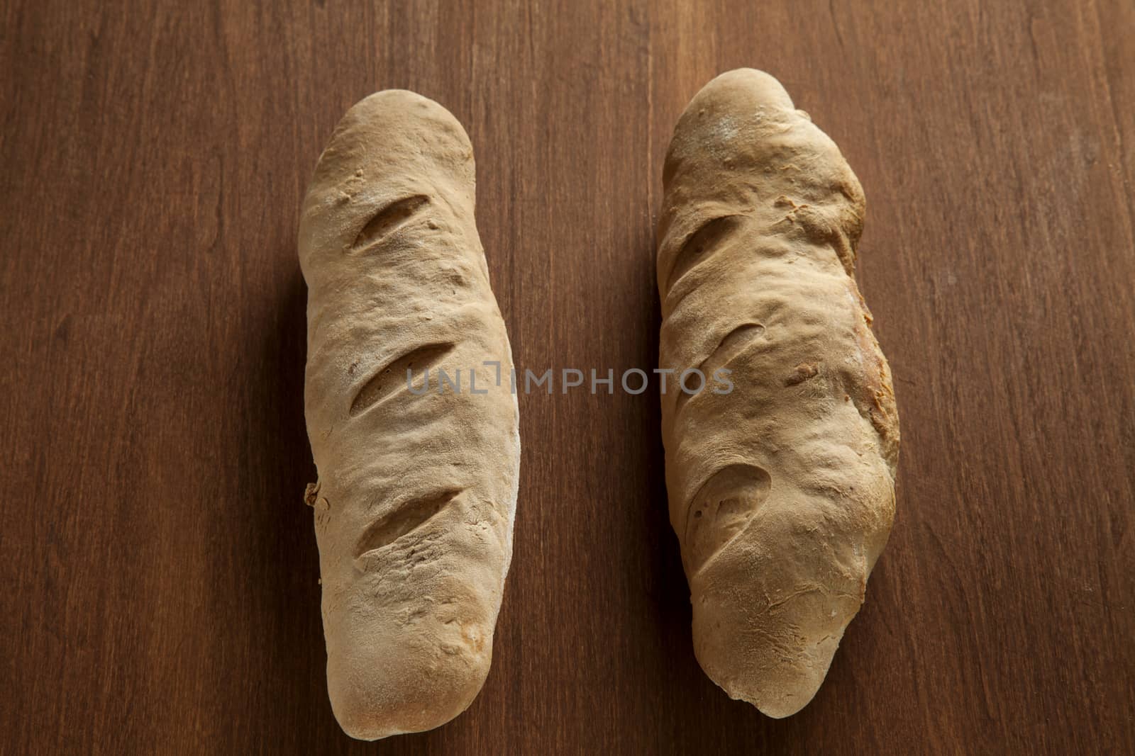 baked bread loaf on wood by haiderazim