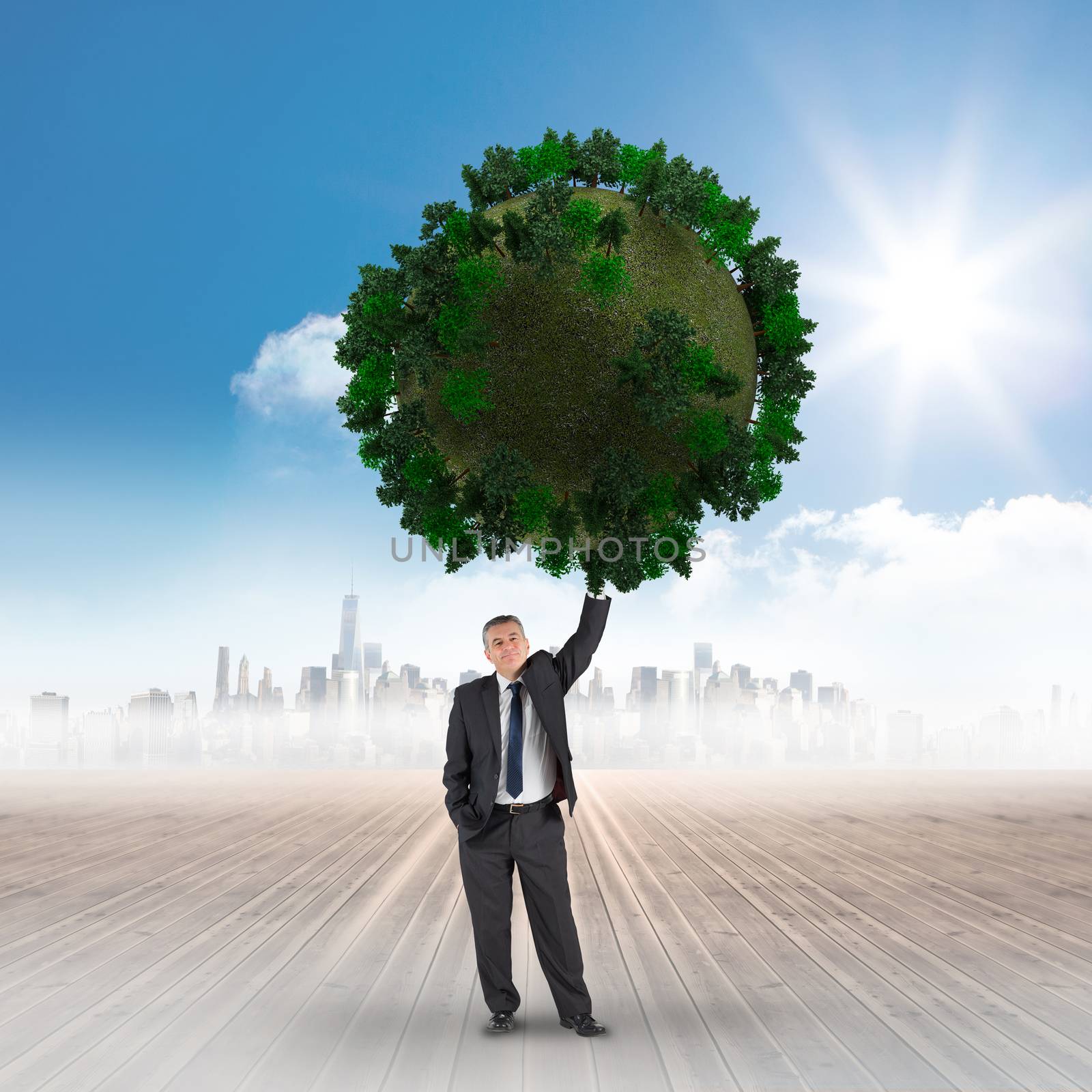 Composite image of businessman holding green sphere against cityscape on the horizon