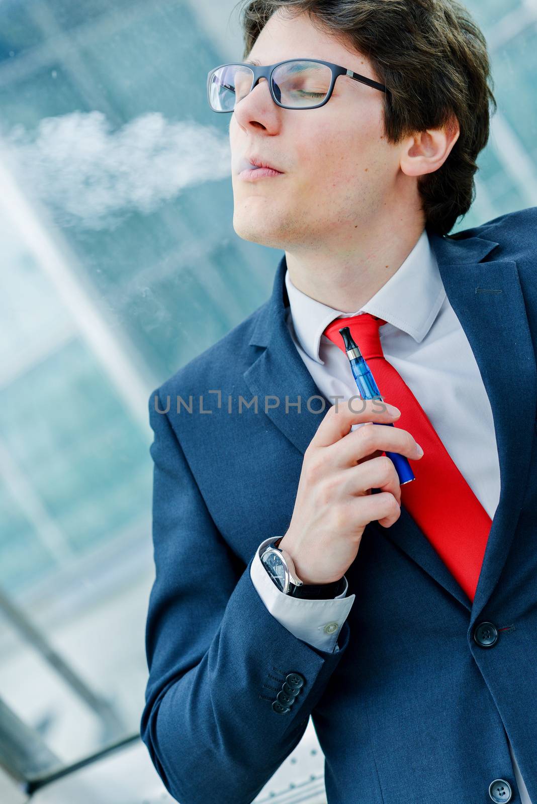  Portrait of cheerful man smoking with e-cigarette outdoor