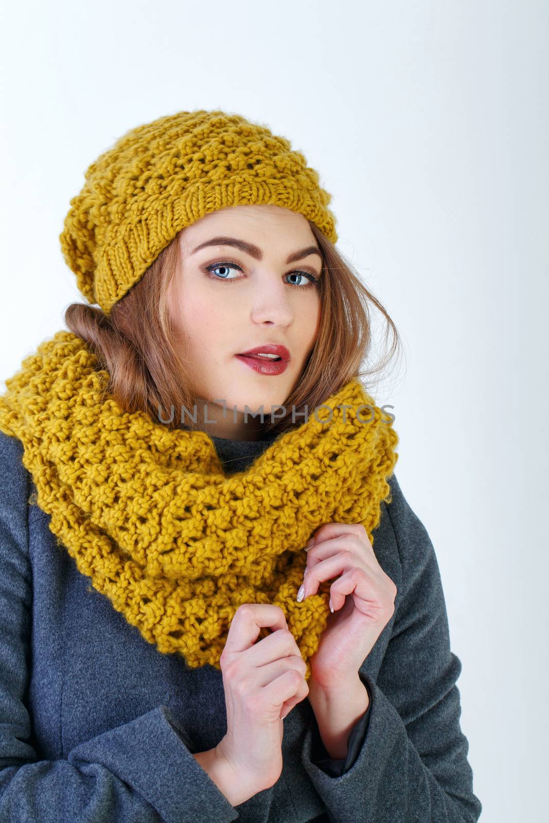 Young attractive Frenchwoman in knitted hat and scarf isolated on white background