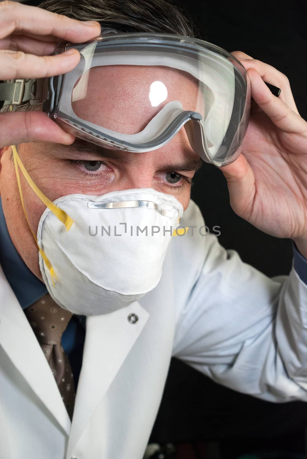 Close-up of a Doctor wearing a mask and putting on goggles.