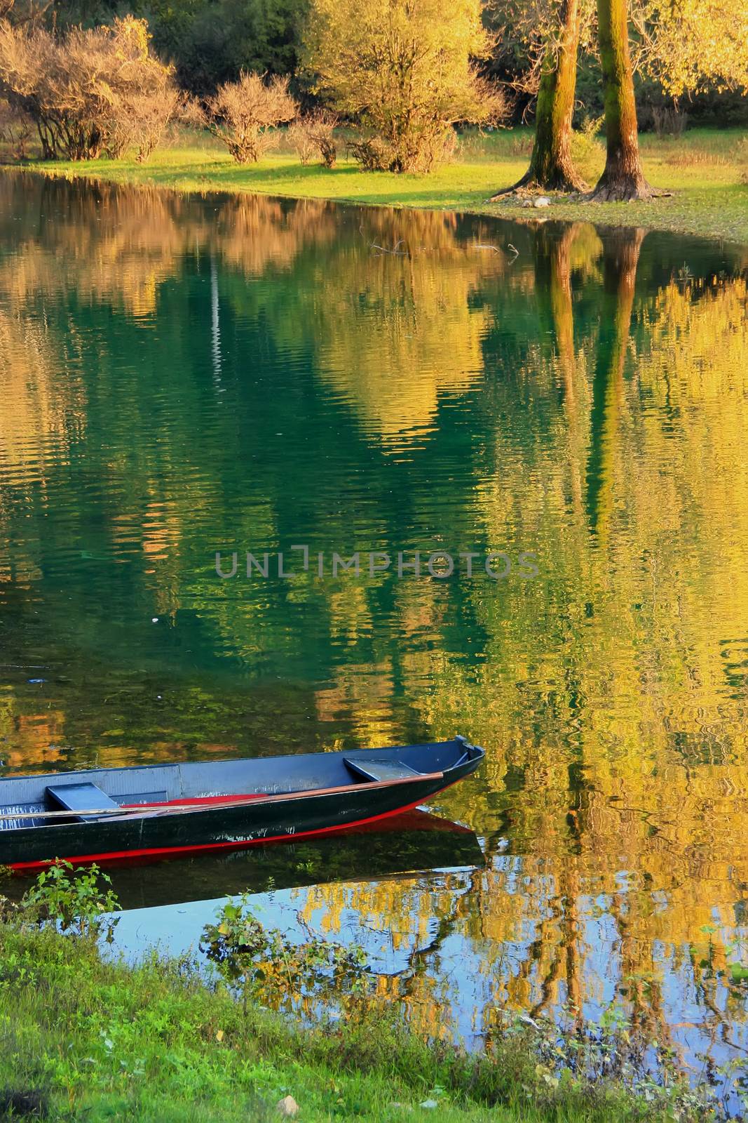 Boat at Crnojevica river with colorful trees reflection, Montene by donya_nedomam