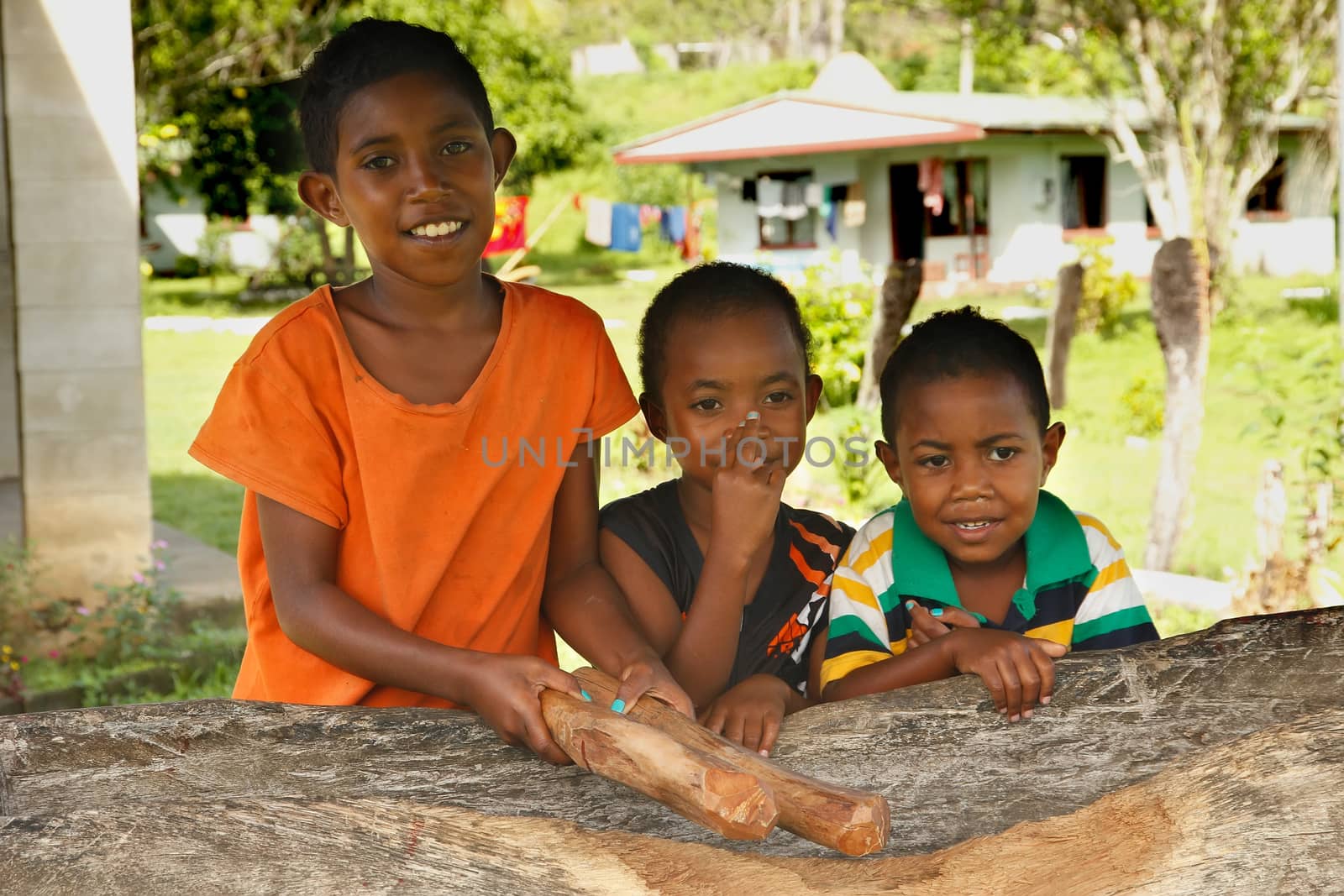 Tree girls standing by the church, Navala village, Viti Levu island, Fiji
