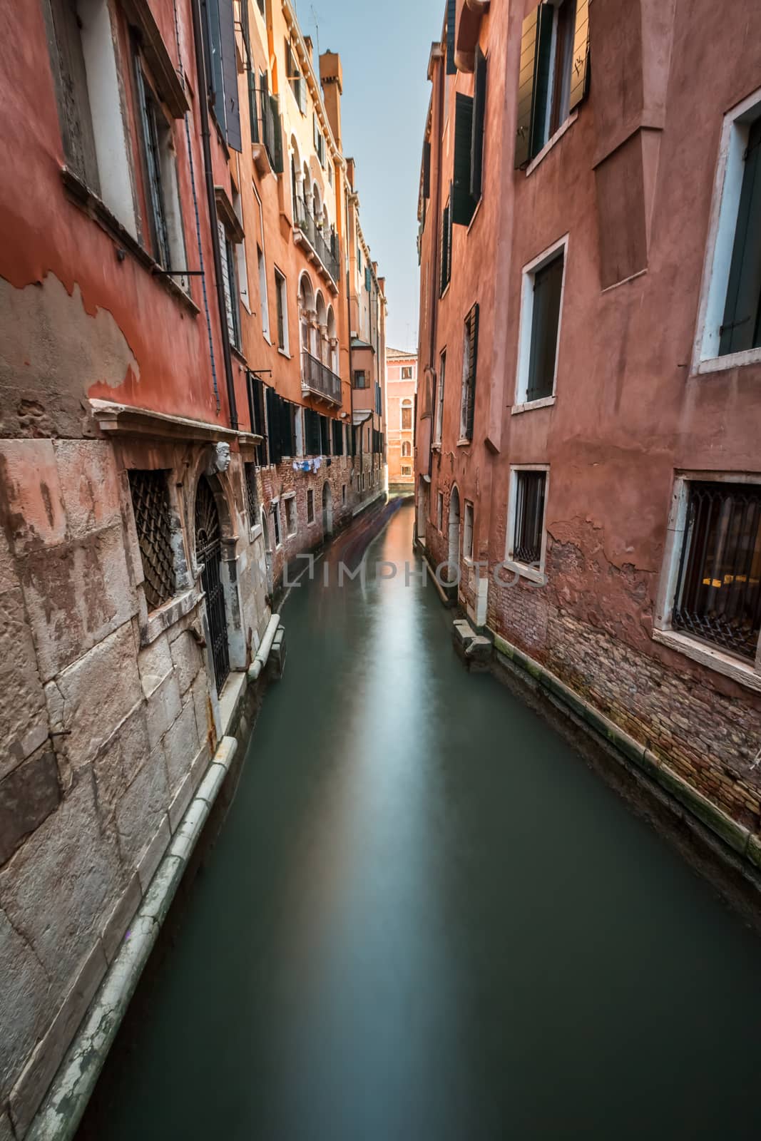 Narrow Canal Among Old Colorful Brick Houses in Venice, Italy by anshar