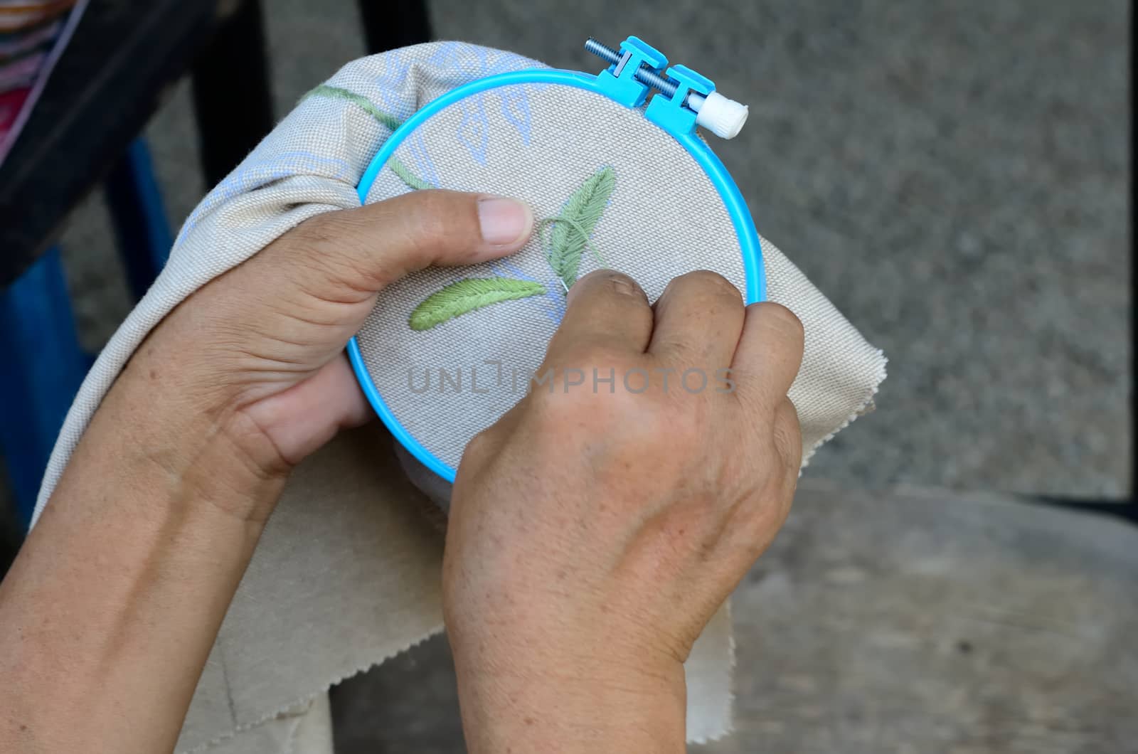 asian woman hands doing cross-stitch,embroidery