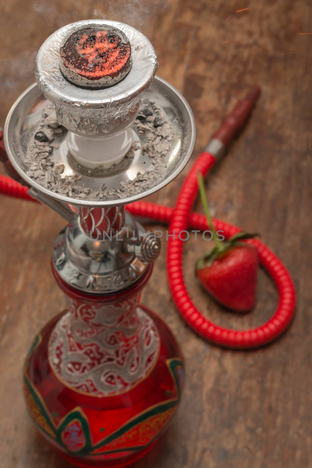 An ornate Syrian sheesha or hooka water pipe on wood table