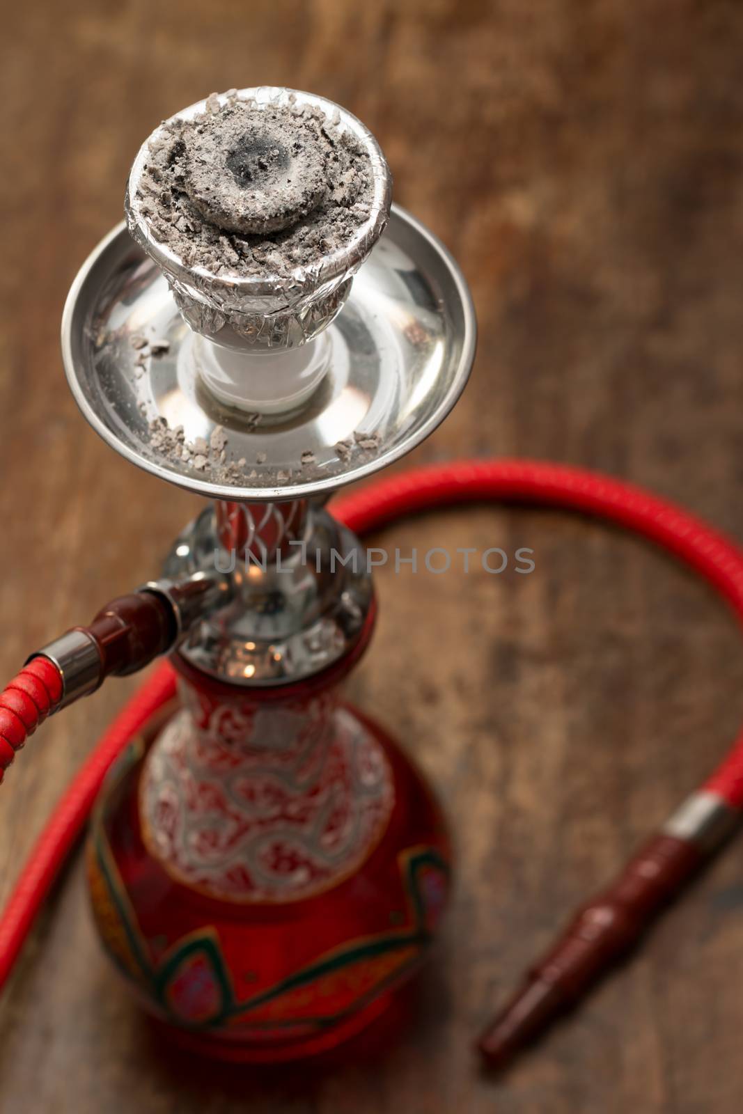 An ornate Syrian sheesha or hooka water pipe on wood table