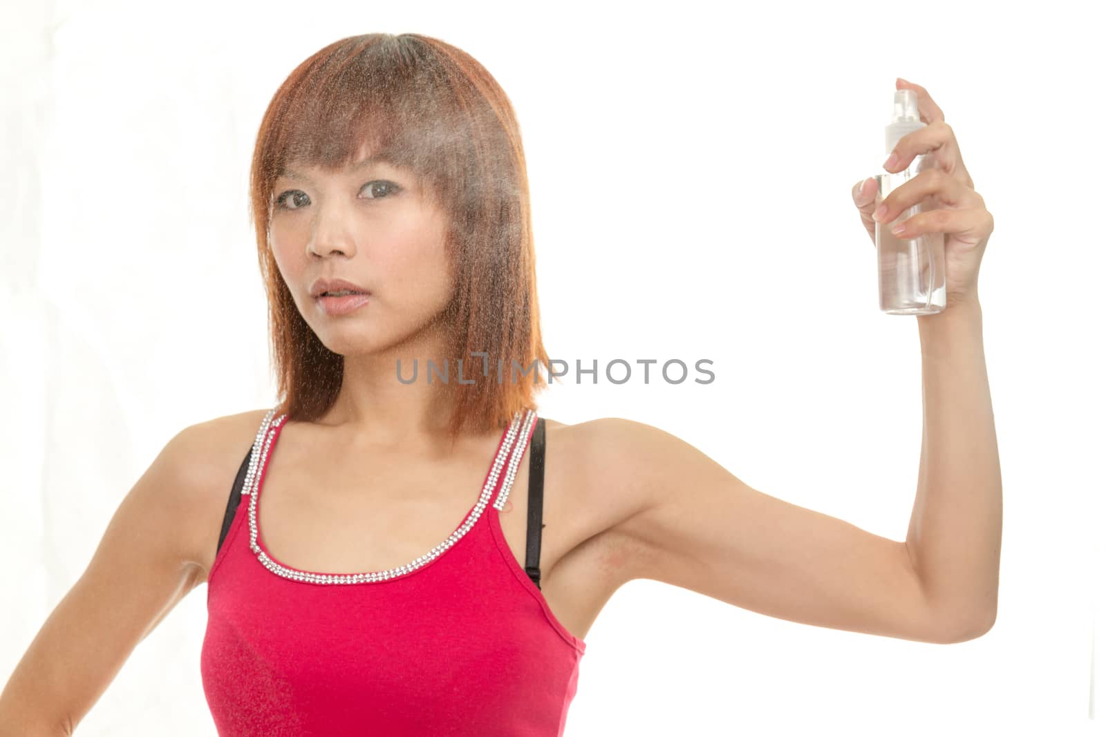 Asian female with water bottle spraying hair