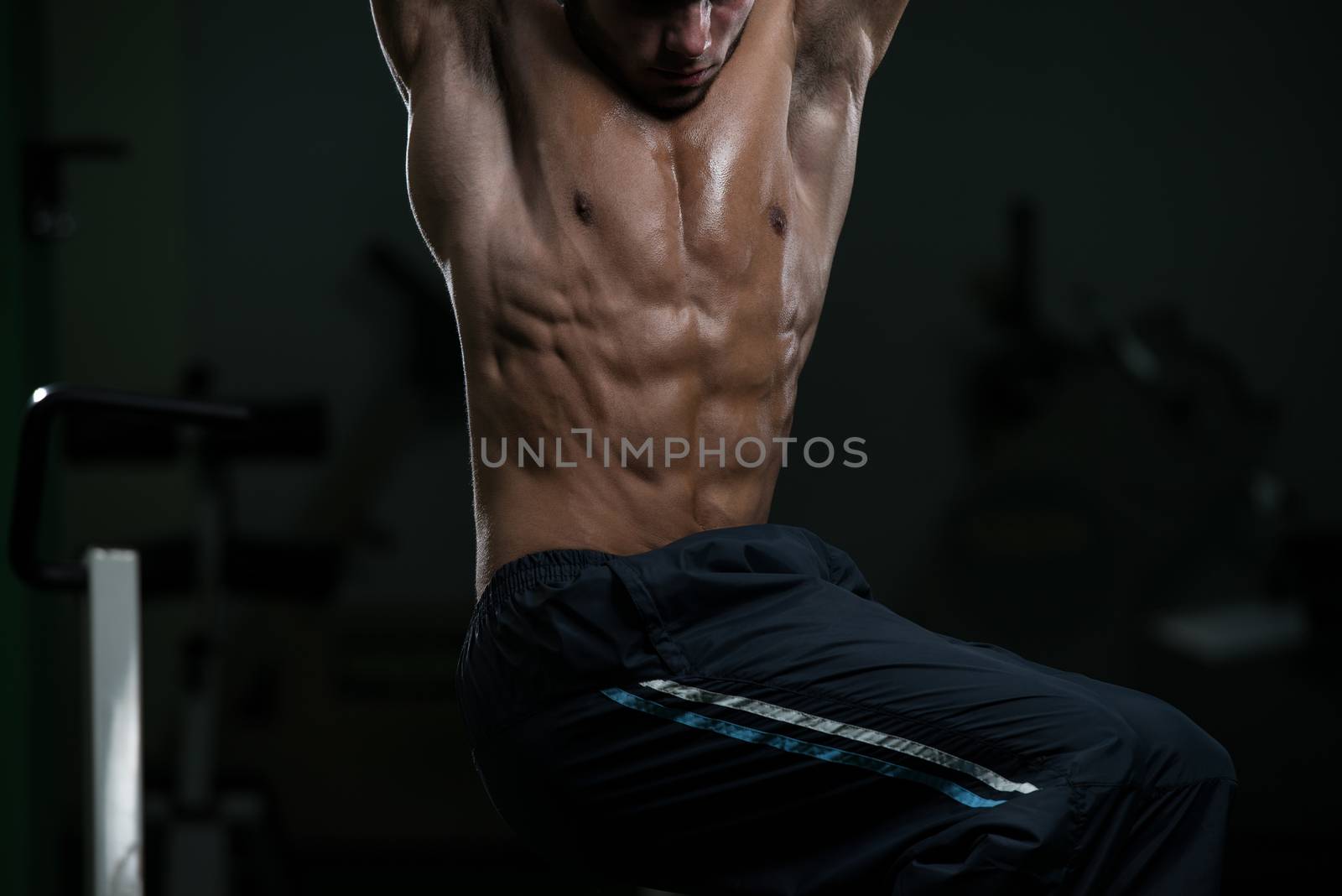 Young Man Performing Abdominal Exercises by JalePhoto