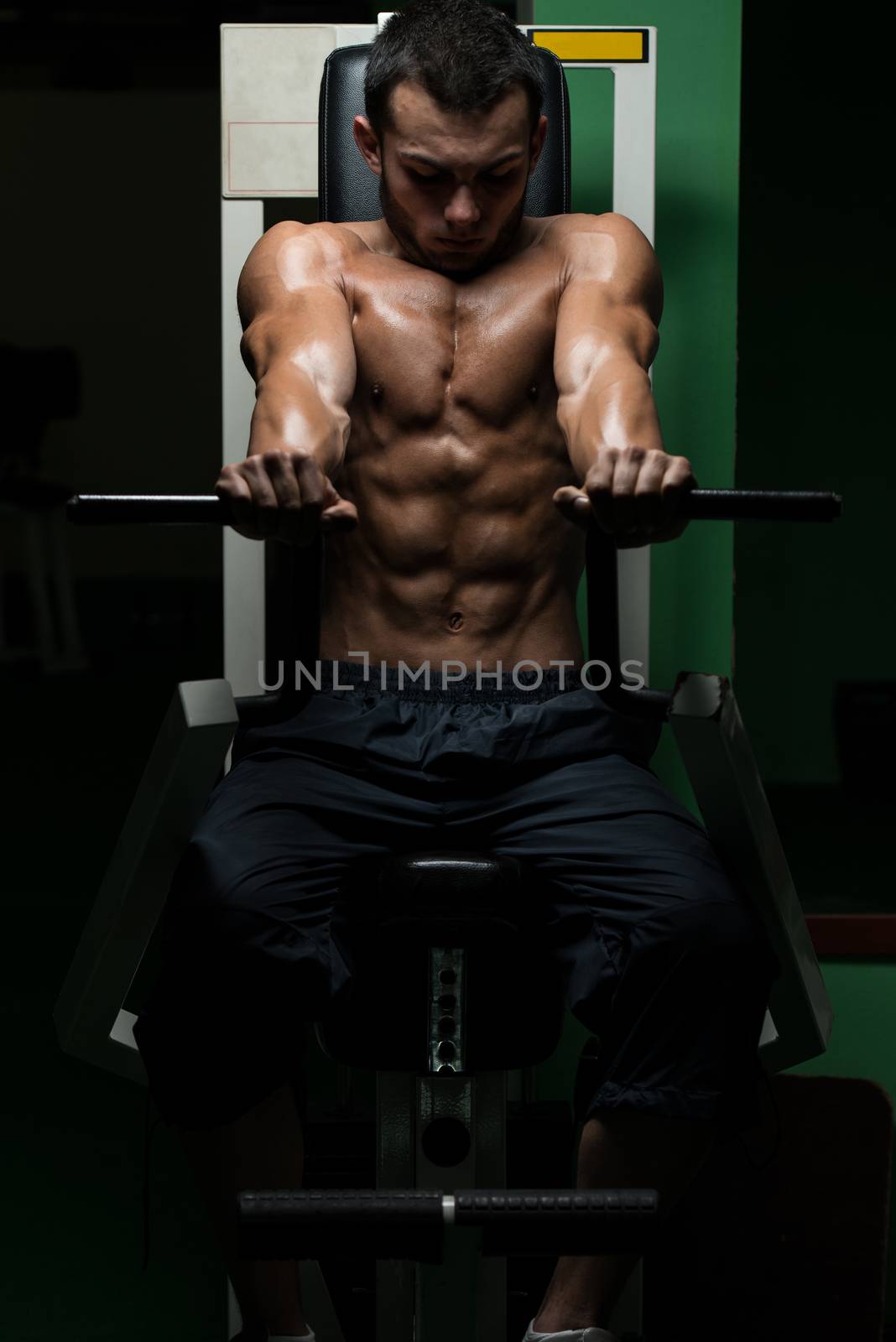 Young Man Doing Heavy Weight Exercise For Chest