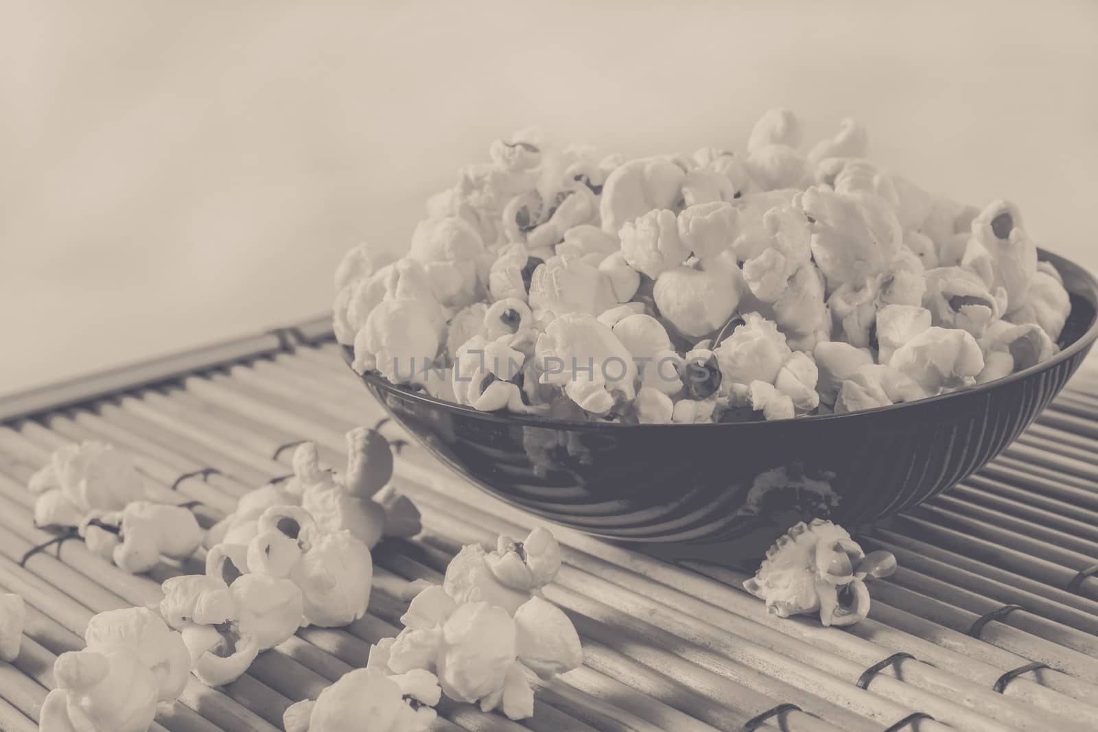 popcorn over filled in bowl and some corn on floor, vintage edited