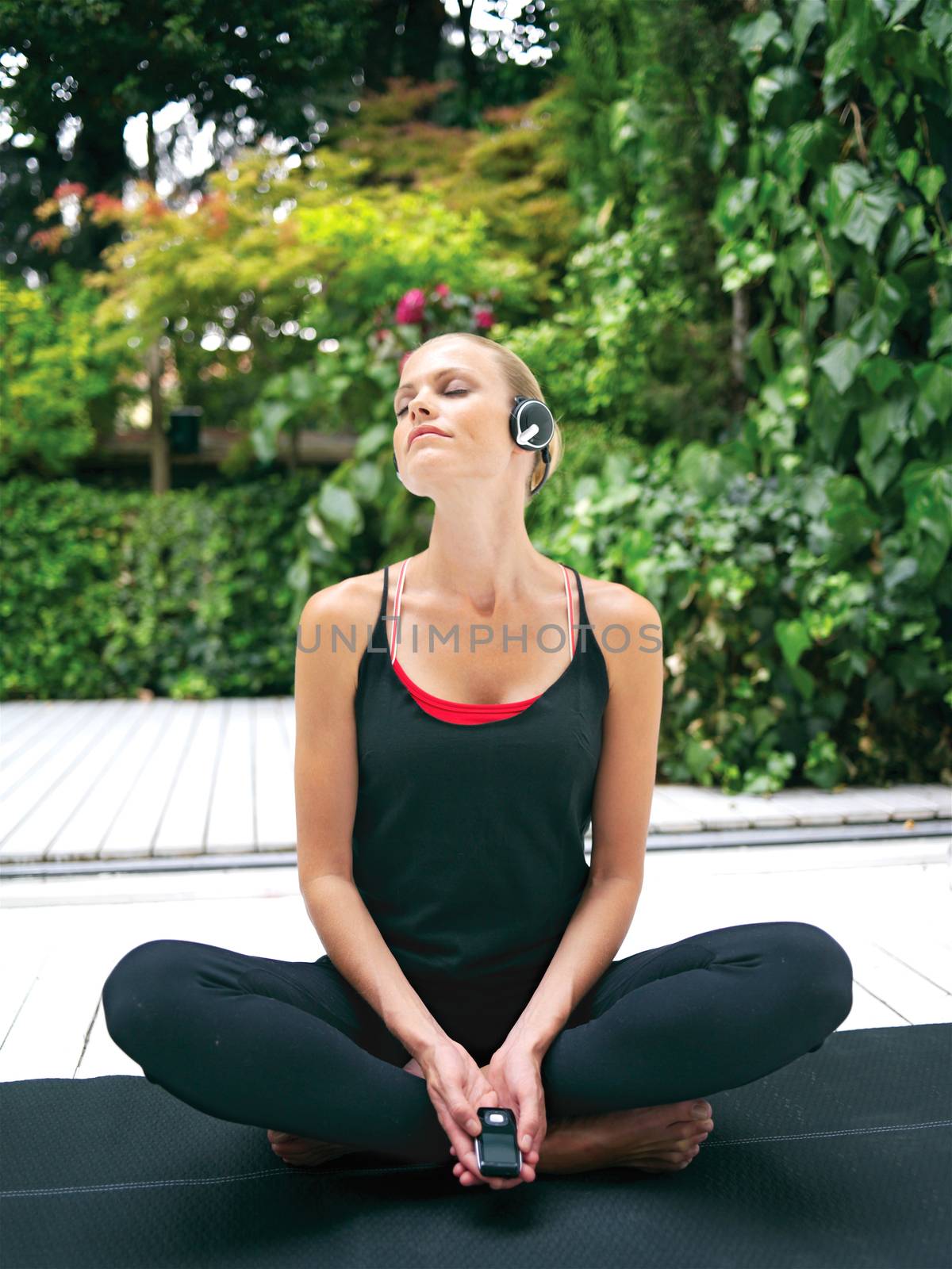woman in earphones doing yoga rt by toocan