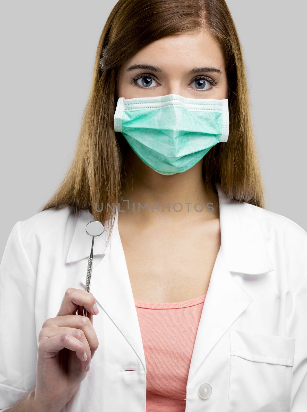 Beautiful and attractive female dentist with tools, isolated over a white background