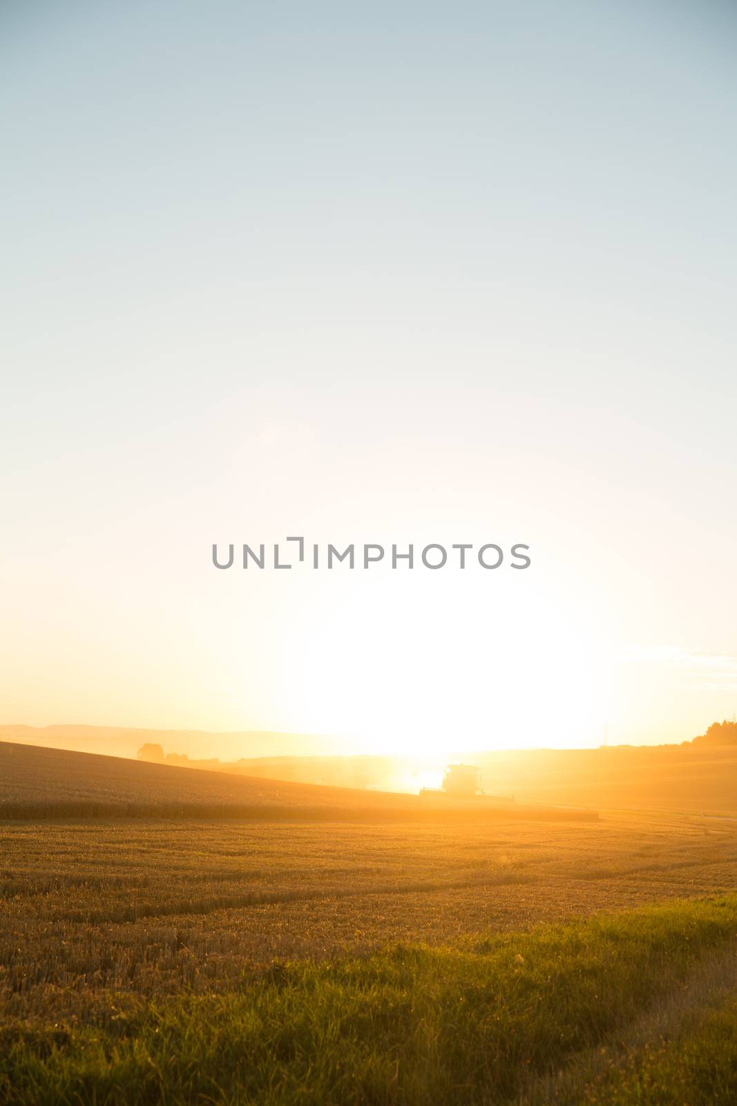 Sunset over a harvested field by Spectral