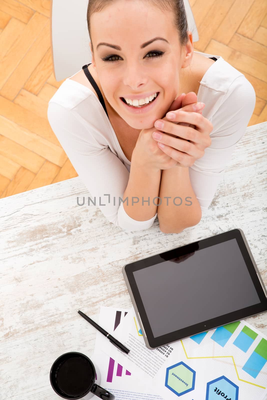 A young adult woman developing a business plan with her tablet PC at home.