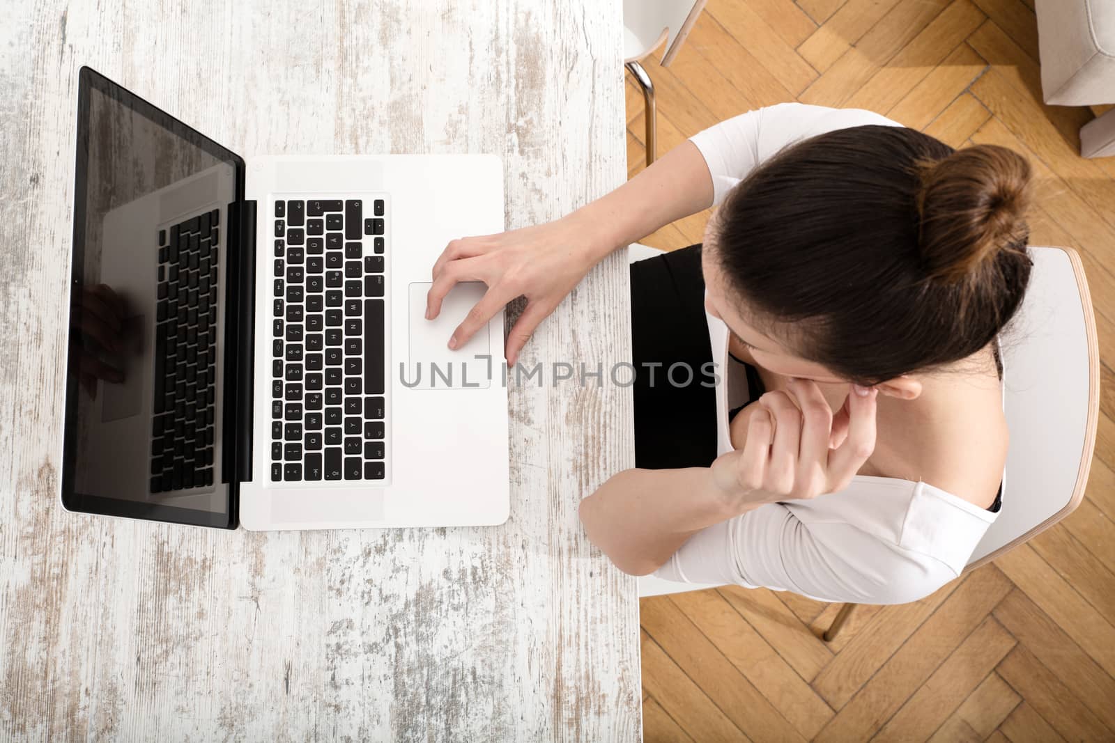 A young adult woman working on a laptop.