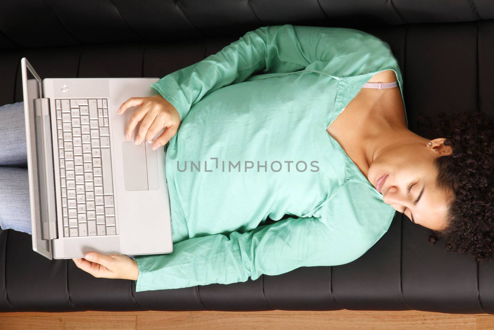 A young, brazilian woman surfing on the Internet with a Laptop.  