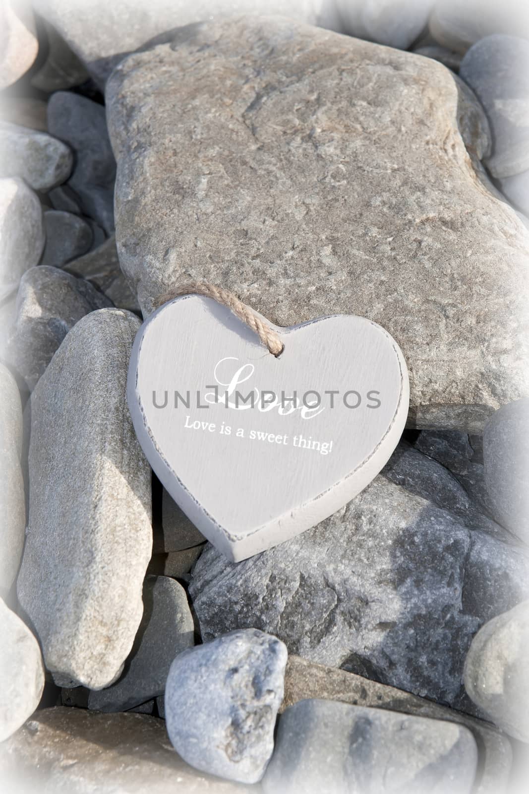 single inscribed grey wooden love heart on a pebble beach in Ireland