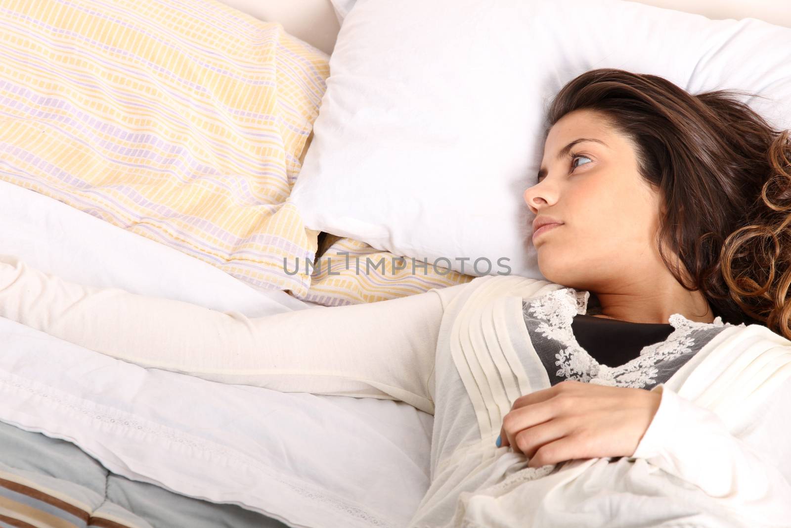 A woman lying alone on the bed.