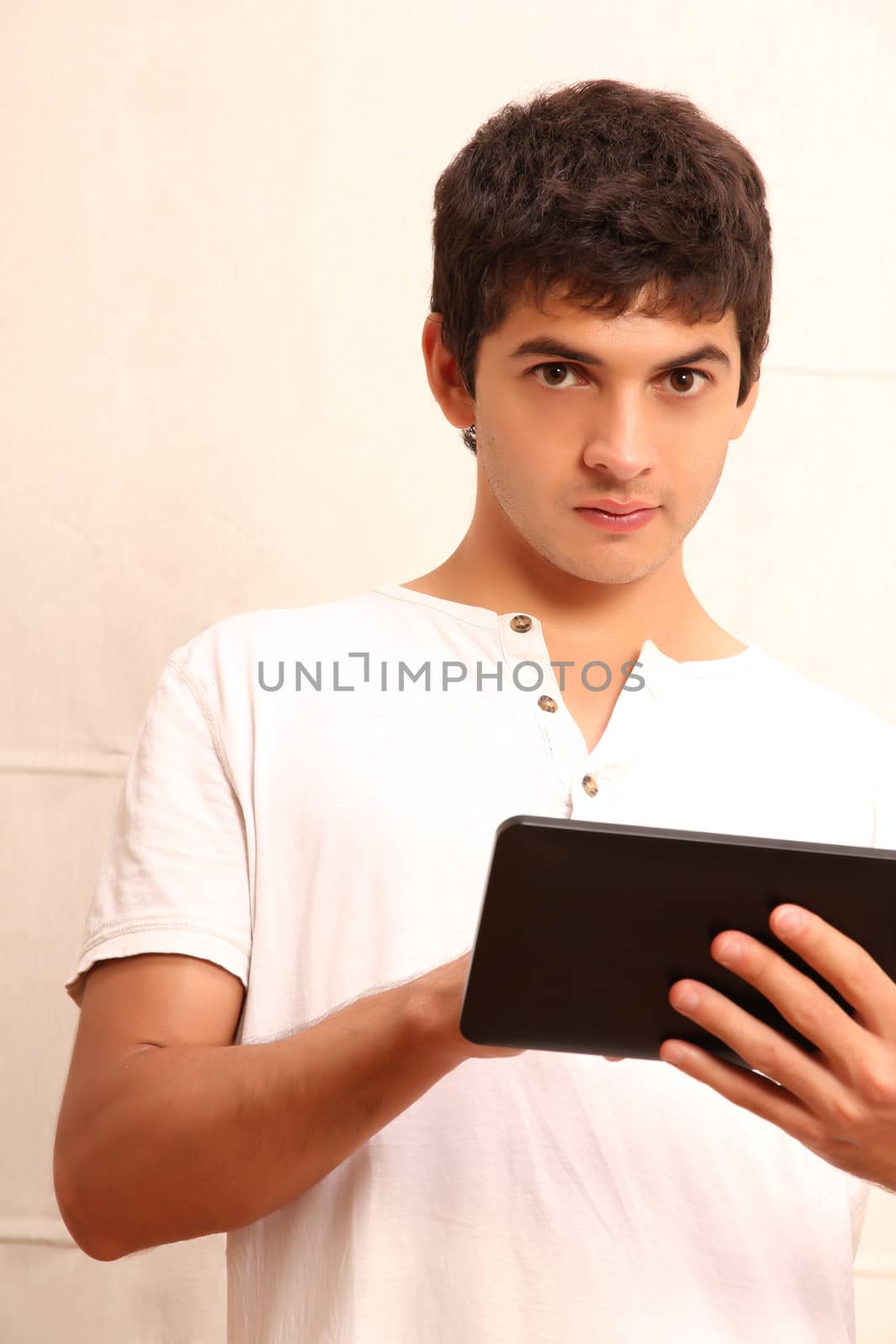 A young, latin man with a Tablet PC, face in focus
