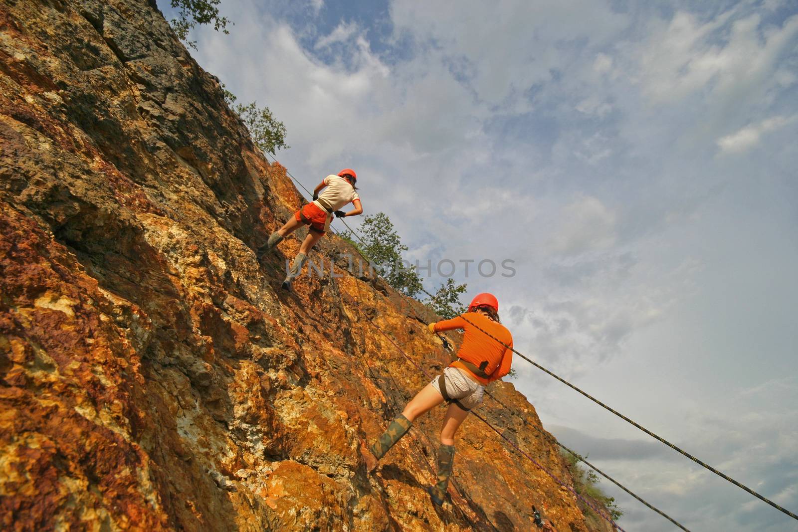 rock climber climbing an overhanging cliff against the blue sky by think4photop