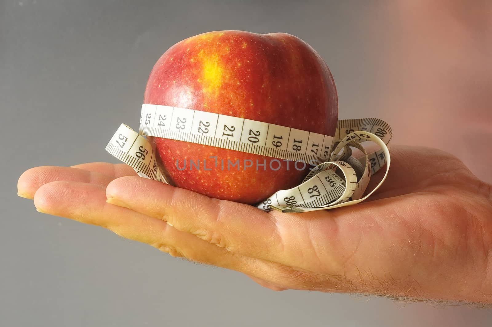 Diet Apple and Meter on the Hand a Colored Background