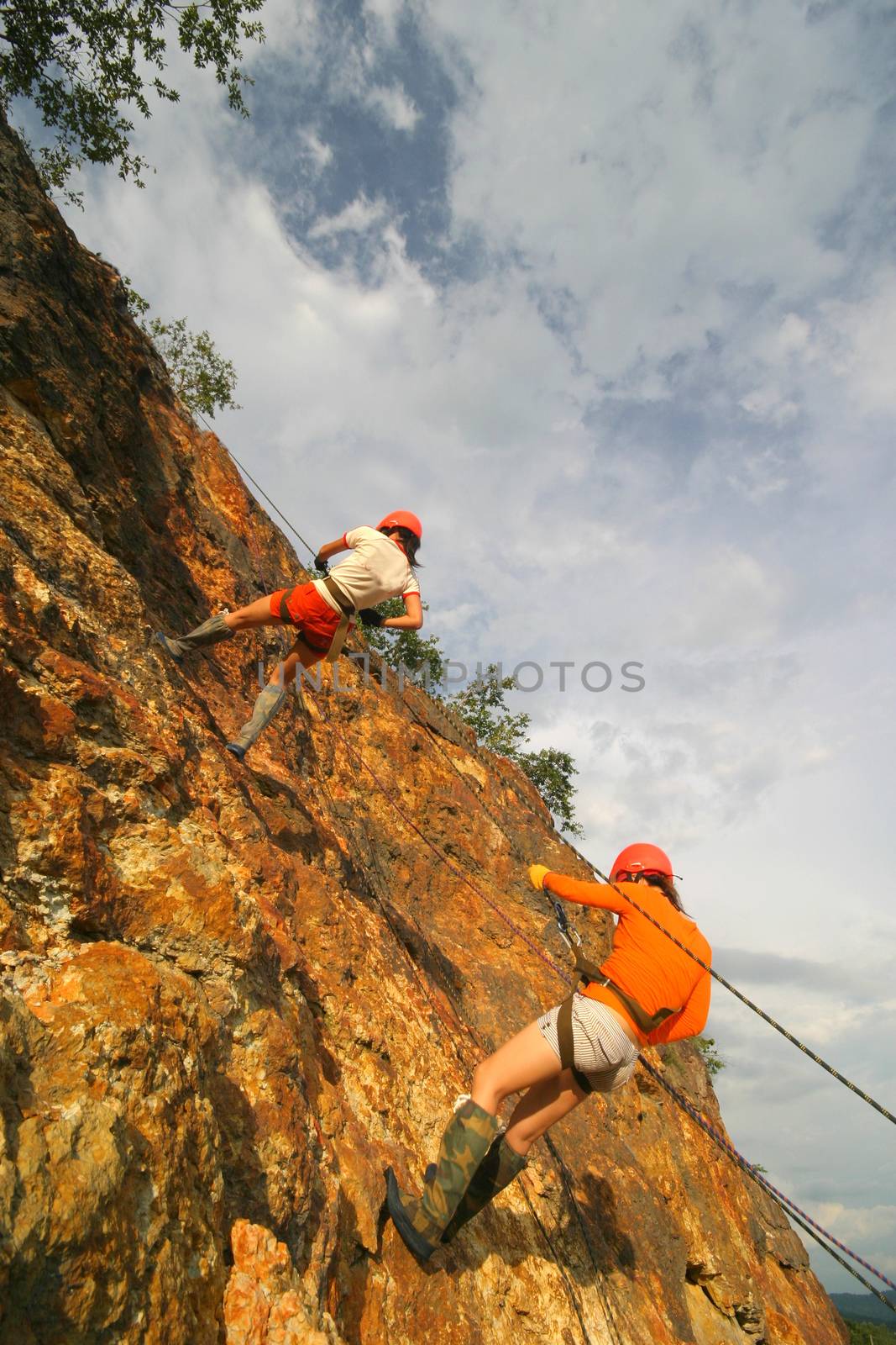 rock climber climbing an overhanging cliff against the blue sky by think4photop