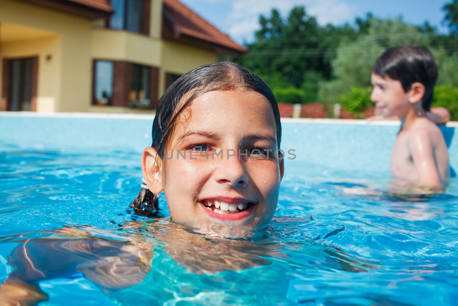 Cute happy girl playing in swimming pool