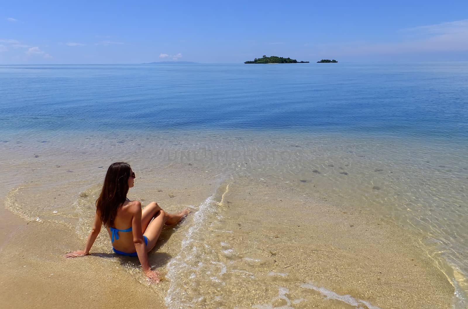 Young woman in bikini sitting on a beach, Vanua Levu island, Fiji, South Pacific