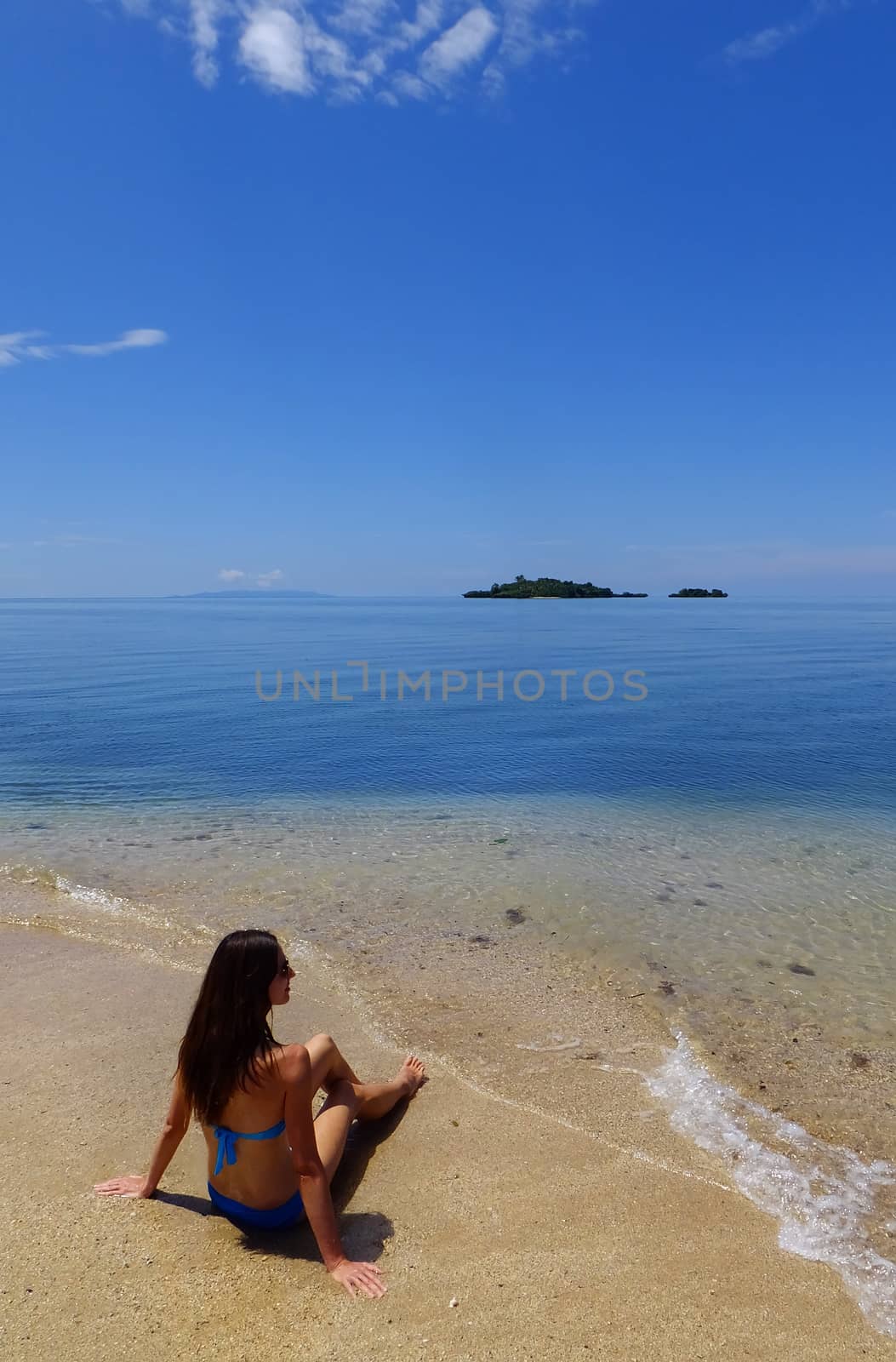 Young woman in bikini sitting on a beach, Vanua Levu island, Fiji, South Pacific