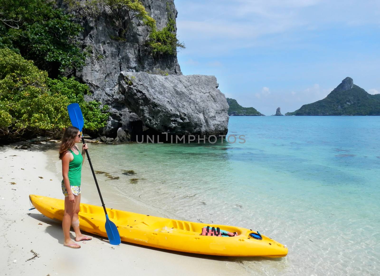 Young woman standing by the kayak, Ang Thong National Marine Park, Thailand