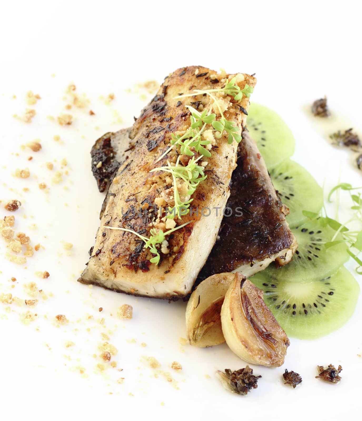 close up fried fish fillet served with kiwi