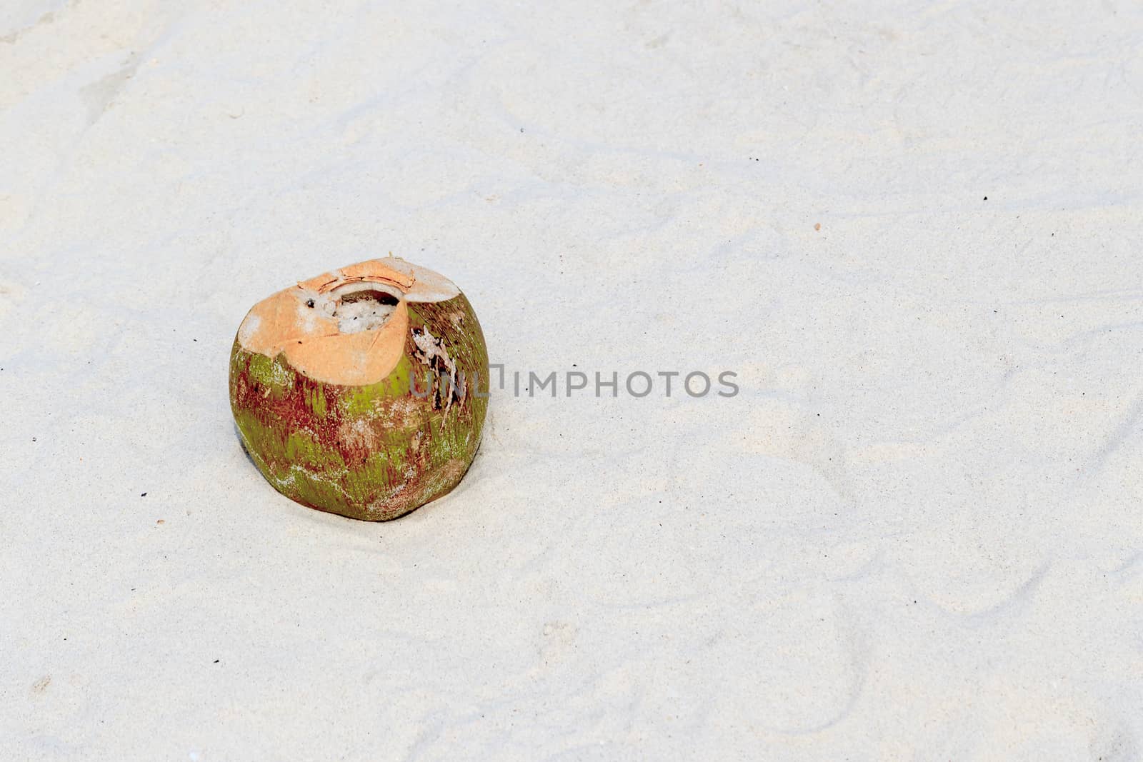 A coconut on white sand floor beautiful.