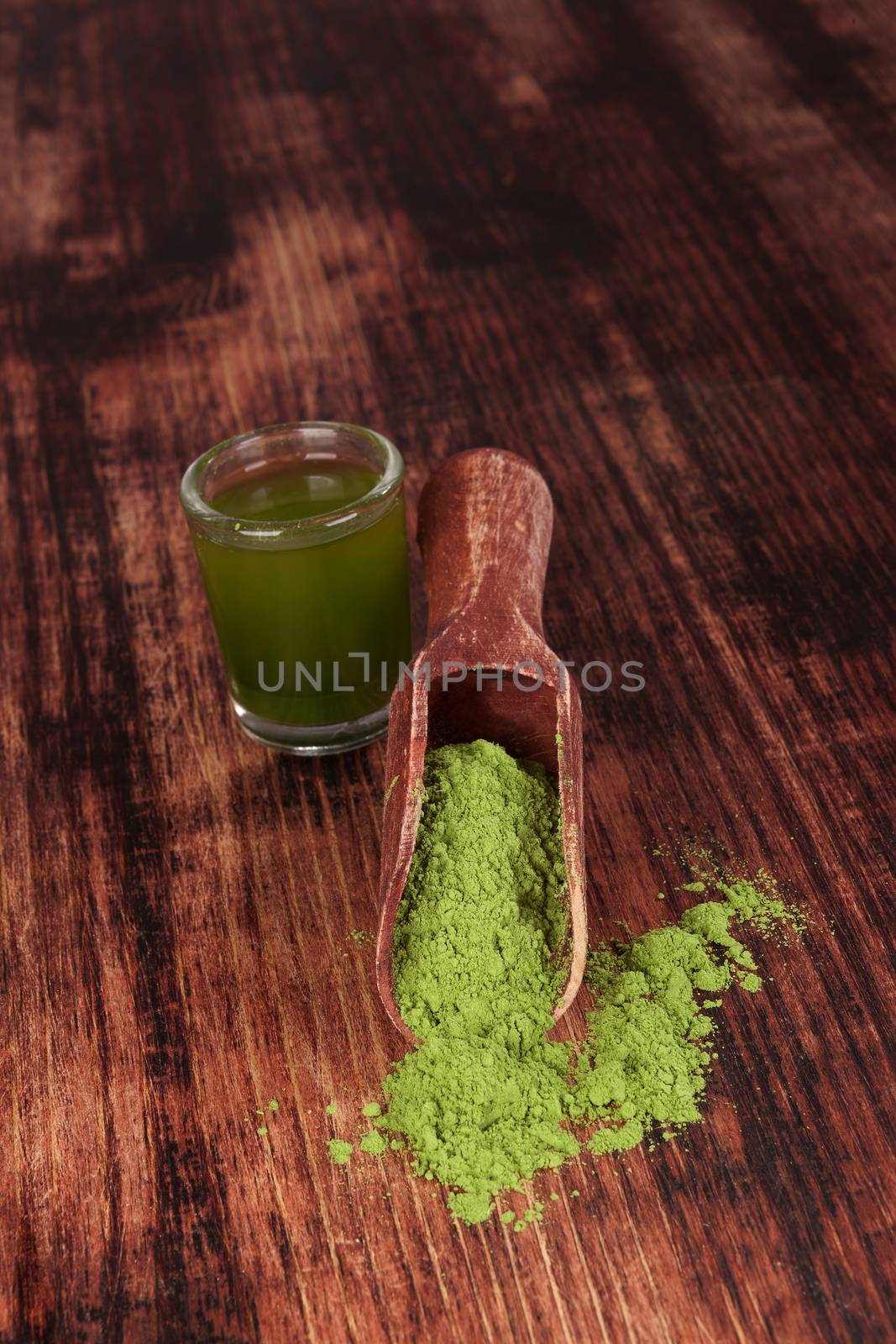 Detox. Wheatgrass ground and green drink on brown wooden background. Healthy alternative medicine.