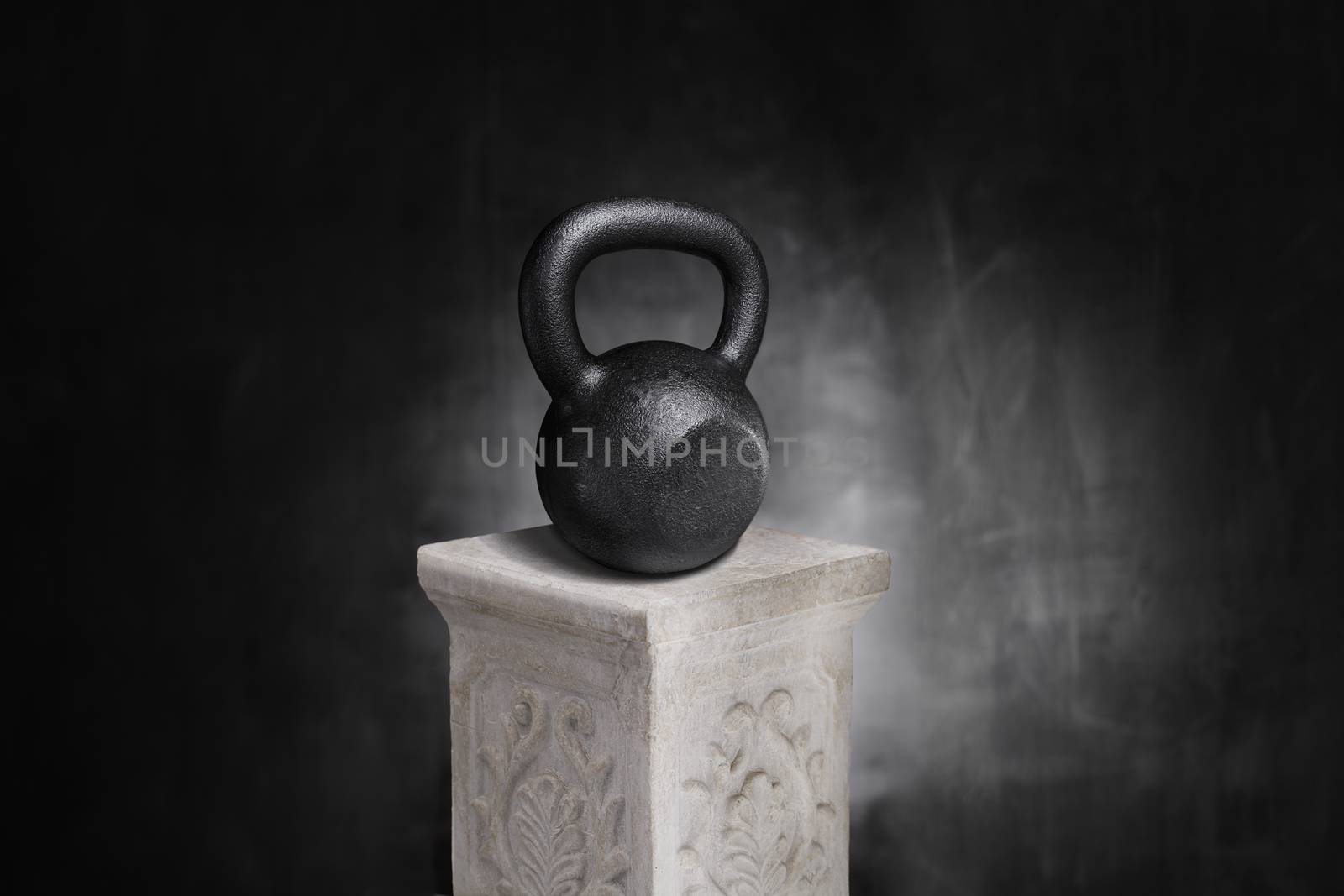 Cast iron kettlebell on a pedestal.