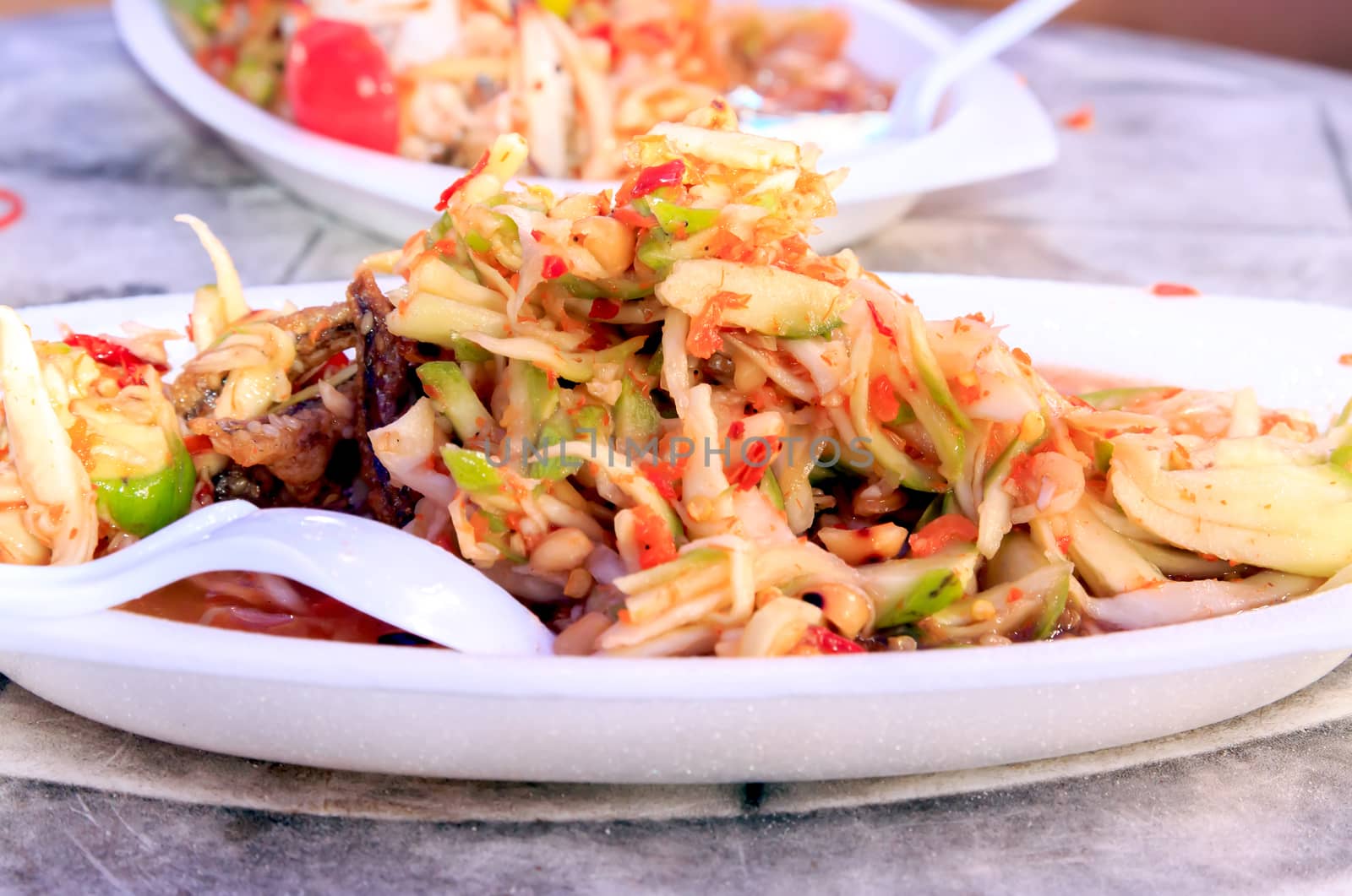 A spicy mango salad with fried fish.