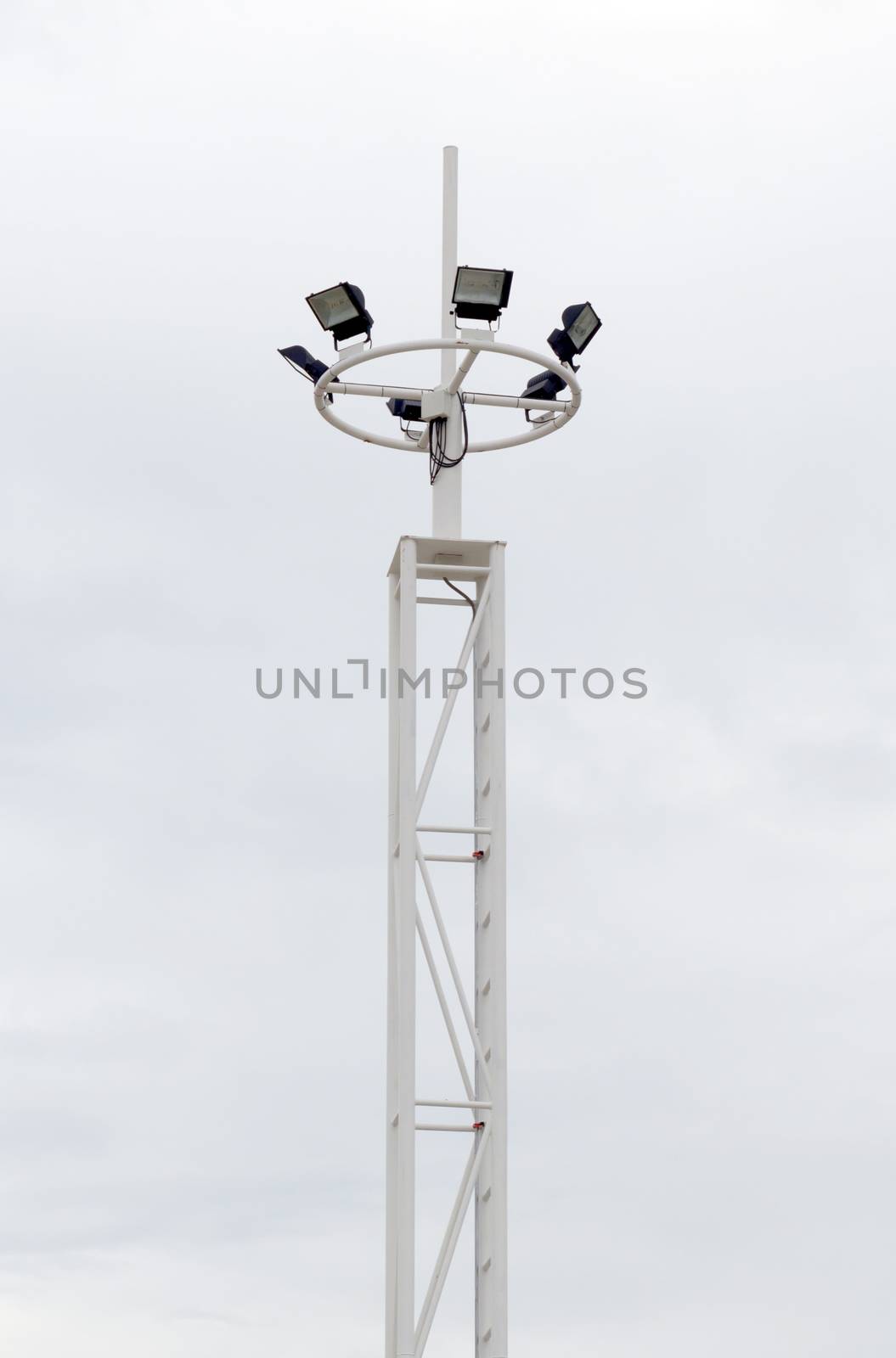 Big spotlight pole on blue sky background.