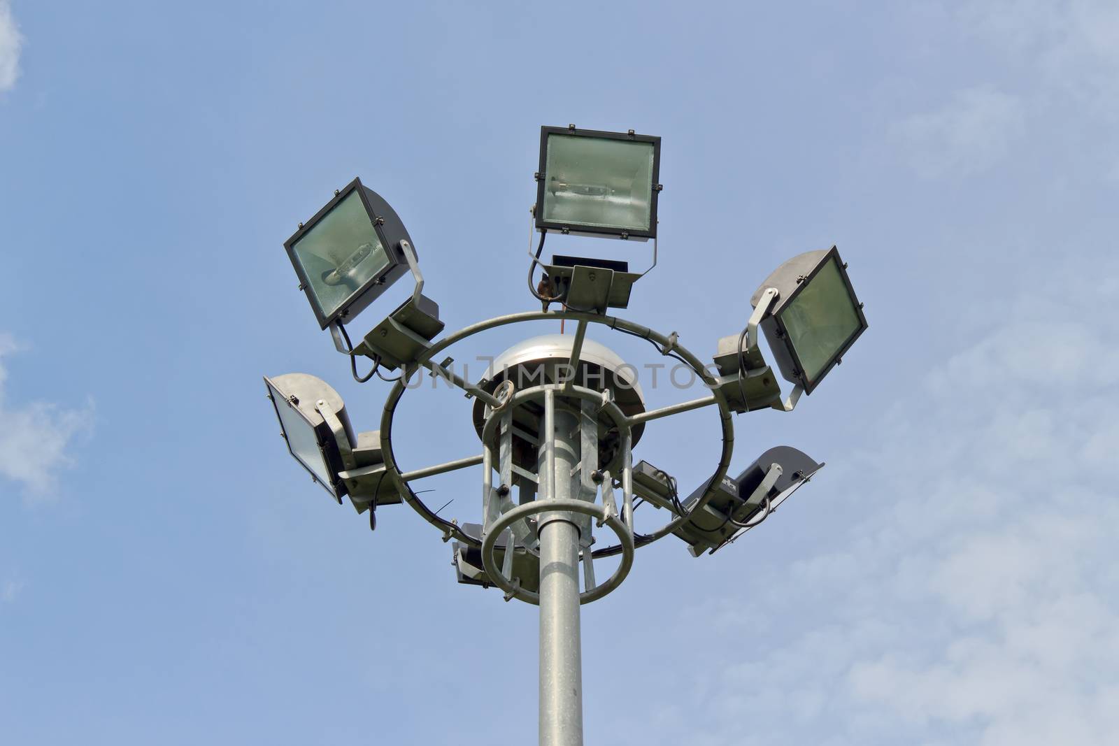 Big spotlight pole on blue sky background.