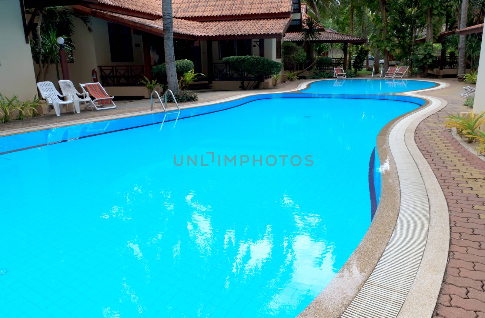 Outdoor in ground residential swimming pool in backyard.