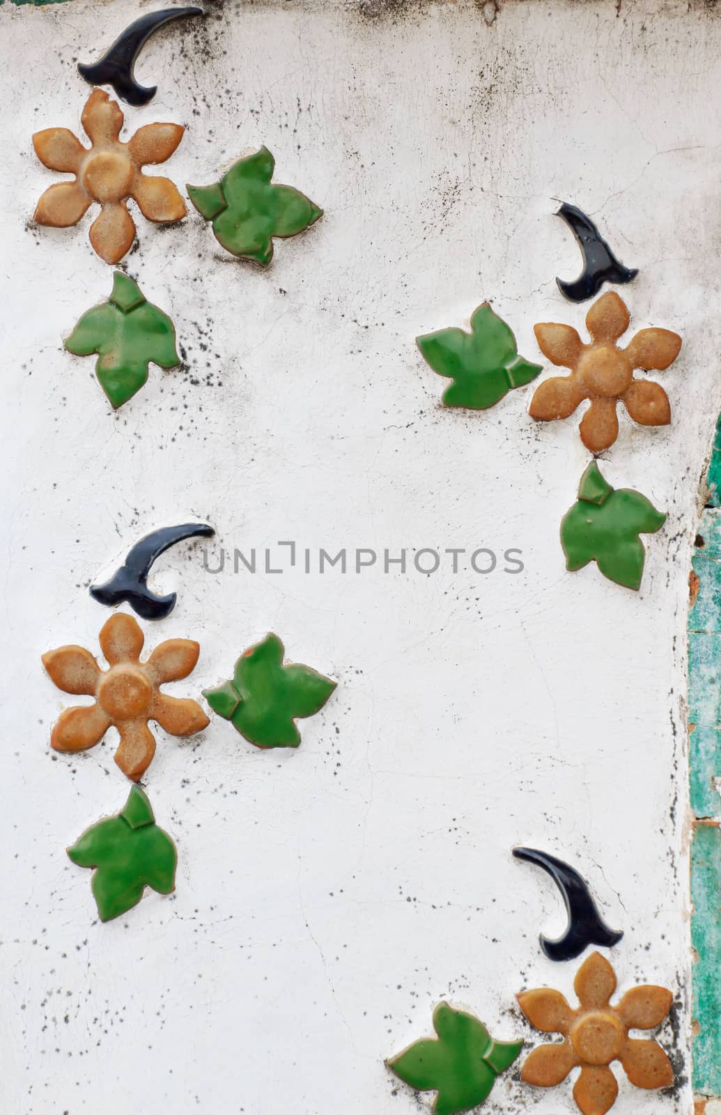 Wall paintings is painted green leaves and flower with white background.